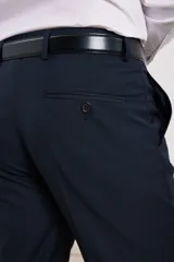 Pantalón de vestir azul marino, de corte recto, con bolsillos laterales y traseros. Se ajusta a la cintura con cinturón de cuero negro.