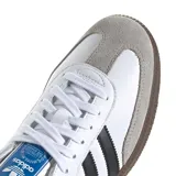 Championes Adidas Samba OG de diseño clásico, color blanco con las icónicas tres tiras negras en los laterales, detalle en la puntera de gamuza gris y suela de goma tipo trampa.
