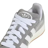 Championes Adidas modelo Campus 00s, confeccionados en gamuza gris con las icónicas tres tiras laterales en blanco. Presentan cordones blancos, suela de goma color crema con base de caucho natural y diseño de corte bajo.