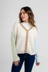 Cárdigan color crema con mangas largas color verde agua y celeste pastel. Tiene cuello en V y botones color madera.