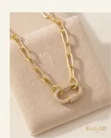 Collar de eslabones rectangulares de acero dorado, con un dije de cierre tipo mosquetón ovalado microdiamantado con circonias blancas.