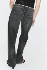 Jeans de tiro bajo con diseño wide leg y corte full length. Presenta cinco bolsillos, cierre frontal con cremallera y botón metálico, en un lavado de denim claro.