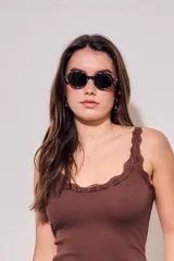 Lentes de sol polarizados de diseño ovalado con armazón carey en tonos marrones y cristales oscuros.