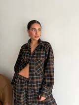 Pantalón de corte recto y holgado, confeccionado en tela de viyela con estampado de cuadros en tonos negro, gris y blanco. Presenta cintura elástica para mayor comodidad.