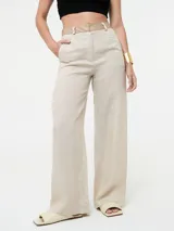 Pantalón de lino color beige claro, de corte ancho y tiro alto, con pretina contrastante de eco cuero color camel.