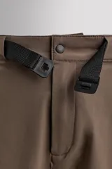 Bermuda de ajuste regular color marrón oscuro, confeccionada en tejido técnico compacto con elasticidad. Presenta cintura ajustable con cinturón negro a contraste, bolsillos frontales y un bolsillo cargo con cierre de cremallera oculta en la pernera.