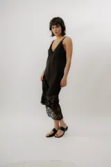 Vestido midi de lino y encaje color negro, con tirantes finos, escote en V y detalle de encaje transparente en el bajo.