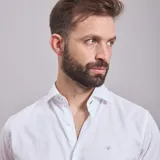 Camisa negra de algodón con cuello clásico, manga larga y cierre frontal con botones. Presenta un logo bordado en el pecho. Corte entallado.