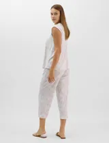 Pijama compuesto por remera sin mangas con escote redondo, botones frontales y detalle de puntilla, acompañado de un pantalón capri con cintura elástica. Presenta un estampado floral en tonos rosados sobre base gris.