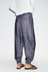 Pantalón jogger de tiro bajo color azul marino con efecto melange, cintura elástica con cordón de ajuste, bolsillos delanteros y puños elásticos en los tobillos.