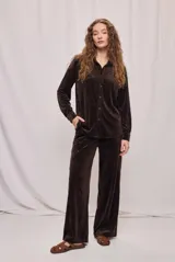 Camisa de calce relajado confeccionada en tejido aterciopelado de tacto suave, color marrón. Diseño con cuello clásico, manga larga con puños y cierre frontal mediante botones. Terminación recta y caída fluida.