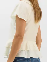 Blusa de satén color rosado con acabado texturizado, escote en V con volados, mangas cortas acampanadas y diseño péplum de doble nivel en la parte inferior.
