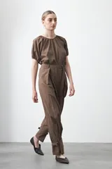 Pantalón baggy negro de silueta relajada con volumen amplio y caída fluida. Presenta detalles de ajuste con hebillas metálicas en el bajo y un cinturón de tela con hebilla metálica en la cintura.