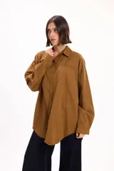 Camisa de corte oversize color marrón, con cuello clásico, cierre frontal de botones y bolsillo en el pecho.