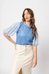 Blusa azul de cuello redondo y manga corta abullonada con puño elástico.