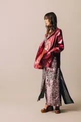 Blazer de cuero color celeste metalizado, con solapas, cierre con broches tipo tanca de madera y puños con detalle de piel sintética marrón.