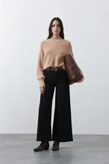 Polera de tejido de punto en color marrón oscuro, con cuello alto y diseño de silueta relajada.