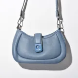 Bandolera celeste de cuero sintético con correa de cadena plateada y cierre con hebilla cuadrada.