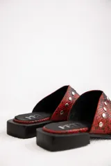 Mules de cuero color marrón oscuro con interior color suela, punta fina y apliques de tachas plateadas.