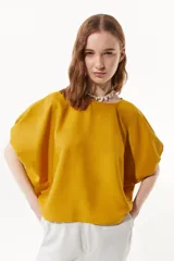 Top corto amarillo de calce oversize con cuello redondo y mangas abullonadas.