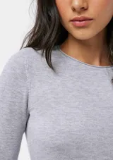 Blusa de punto gris claro melange, de tejido liviano, corte ajustado al cuerpo, cuello redondo y manga larga.