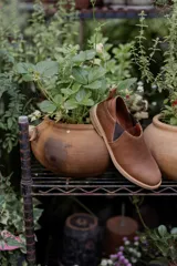 Zapatos tipo chelsea de cuero color marrón, con paneles elásticos laterales y suela plana de goma.