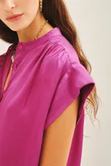 Camisa de corte amplio y mangas cortas, con cuello mao y cierre frontal de botones. Confeccionada en tejido fluido con acabado satinado.