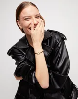 Pulsera de hilo negro ajustable con dije central de perla shell y fornitura bañada en oro de 18k.