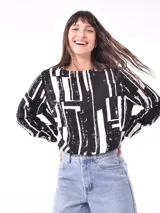 Blusa de mangas largas con estampado de hojas en tonos celeste y azul marino, con lazo en la cintura.