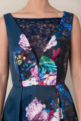 Vestido italiano azul con estampado floral en tonos rosa, blanco y verde. Presenta detalle de encaje en el escote, corte a la cintura y falda con tablas.