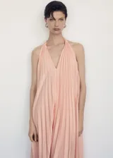 Vestido largo color salmón con escote halter y diseño plisado.
