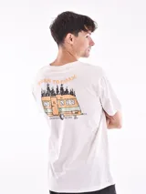 Remera color arena con cuello redondo y estampado pequeño en el pecho.