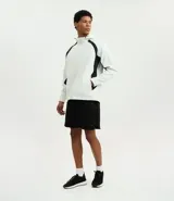 Campera deportiva con capucha, color blanco con recortes laterales en negro. Cuenta con cierre frontal, bolsillos funcionales y ajuste en la cintura.