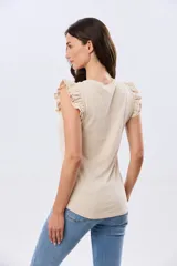 Remera de algodón azul melange con escote redondo y mangas cortas adornadas con doble volado de broderie en los hombros.