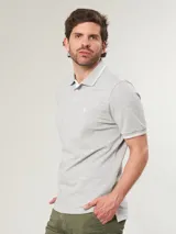 Chomba gris de piqué con cuello clásico con borde blanco, tapeta de dos botones y logo bordado en el pecho.