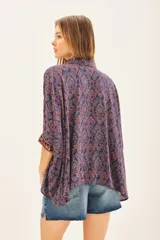 Camisa de algodón con estampado floral en tonos azul y rojo, corte amplio y mangas 3/4 con detalle bordado en los puños.