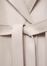 Abrigo largo de corte recto y diseño tipo batín, confeccionado en mezcla de lana. Presenta cuello con solapas, cierre mediante cinturón ajustable en la cintura, mangas largas y abertura posterior en el bajo.