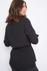 Camisa blanca de seda, estilo cazadora, con mangas largas con presilla para recogerlas, abotonada adelante con lazo que frunce en la cintura.