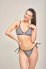 Conjunto de bikini con corpiño triangular con aro y tanga con tiras de atar, con estampado de cuadros vichy en blanco y negro.
