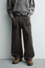Pantalón de corte relaxed fit confeccionado en algodón, color gris oscuro. Presenta bolsillos delanteros, bolsillos laterales tipo cargo en las perneras y cierre frontal con cremallera y botón.