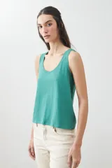 Musculosa verde con escote redondo a la base y sisas anchas.