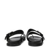 Sandalias Miss Carol modelo Talira de color negro, con diseño plano, tiras dobles decoradas con tachas metálicas plateadas, hebilla ajustable y tira separadora para el dedo.
