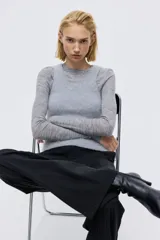 Pantalón de vestir con corte bootcut, confeccionado en tela negra con diseño de rayas finas verticales. Presenta cierre frontal con pretina prolongada, bolsillos laterales al bies y bolsillos traseros ribeteados, con detalle de raya marcada en el frente y la espalda.