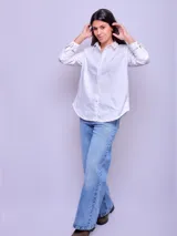Camisa de dama suelta, 100% algodón, color blanco, con cuello clásico, botones frontales y mangas largas con puños abotonados.
