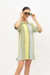 Vestido corto tejido en algodón con lurex, con cuello tipo camisa, abotonado al frente y mangas cortas.