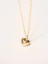Collar dorado con dije en forma de corazón.