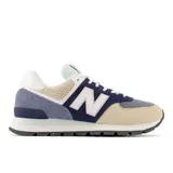 Championes urbanos New Balance modelo 574, con capellada de gamuza color beige, detalles en azul marino y celeste, y logo "N" característico en los laterales.