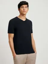 Camiseta de manga corta con cuello en V, color blanco, confeccionada en tejido flamé.