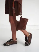 Zapatillas bajas marrones de gamuza con detalles de estampado animal print.