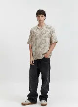 Camisa de manga corta con cuello tipo pijama y estampado abstracto en tonos beige.